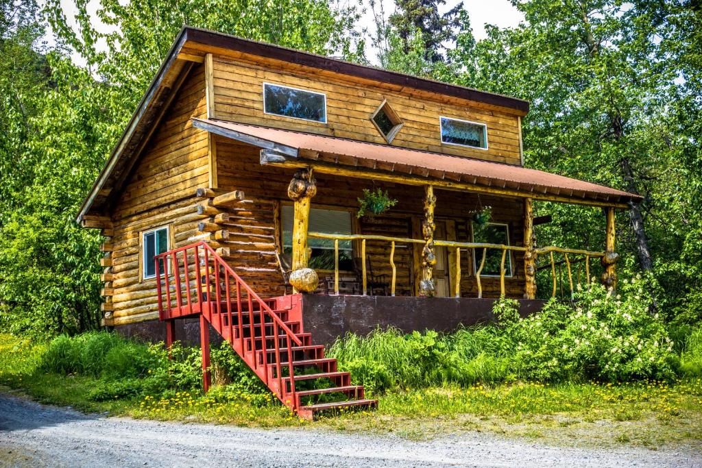 Moose Pass午夜太阳山林小屋的小木屋前方设有红色楼梯