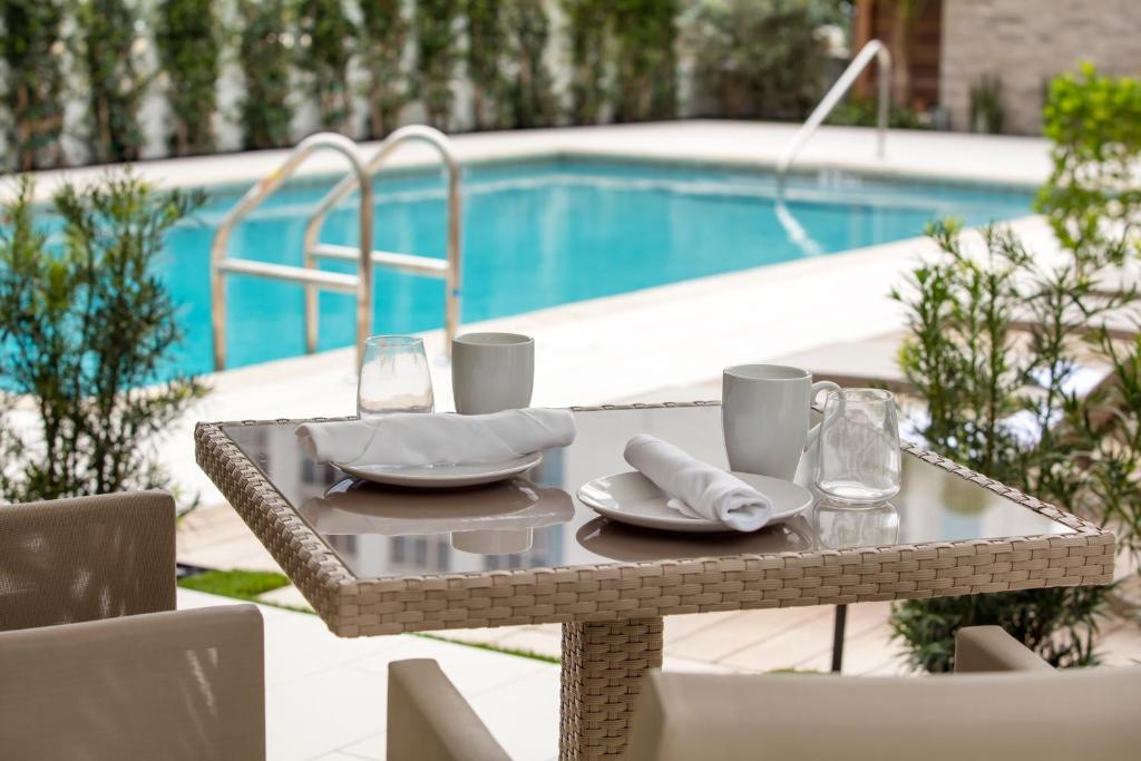 劳德代尔堡伊丽塔汽车旅馆的游泳池旁一张桌子,上面有盘子和餐巾