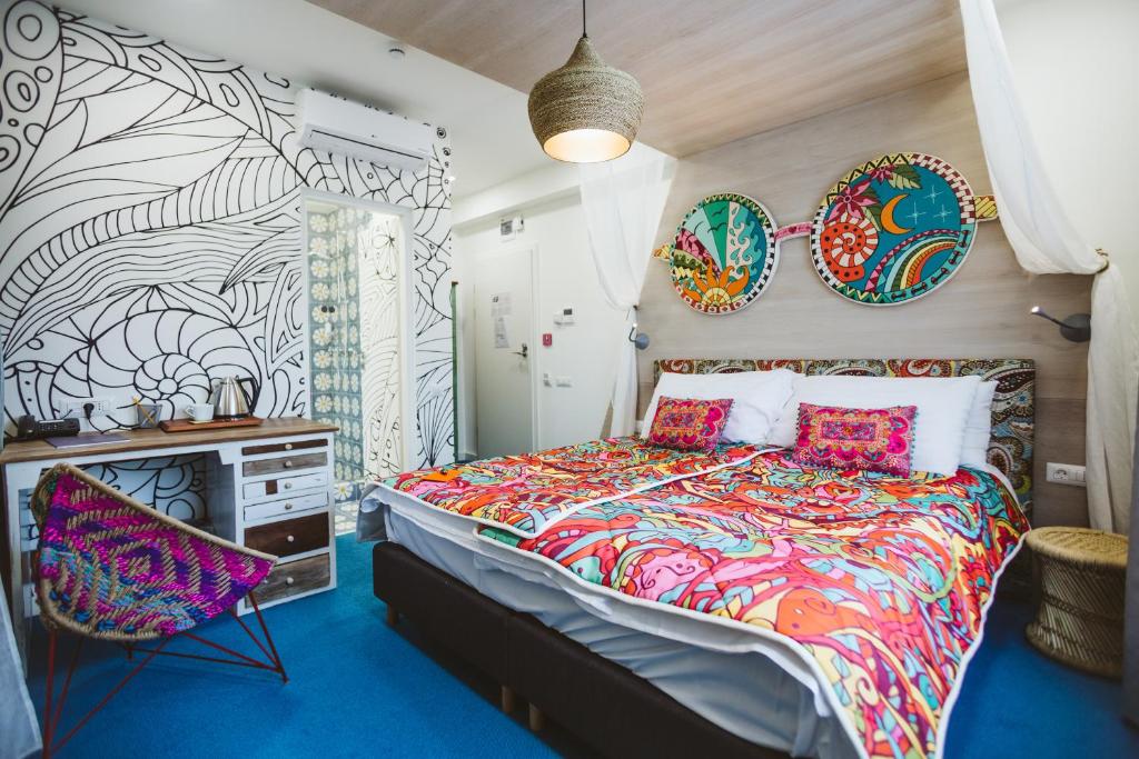 克卢日-纳波卡洛尔和洛拉酒店的一间卧室配有一张带五颜六色棉被的床