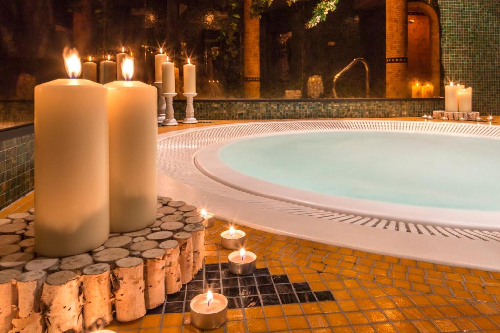 蒙圭尔福奥林匹亚小屋酒店的浴室配有蜡烛和浴缸