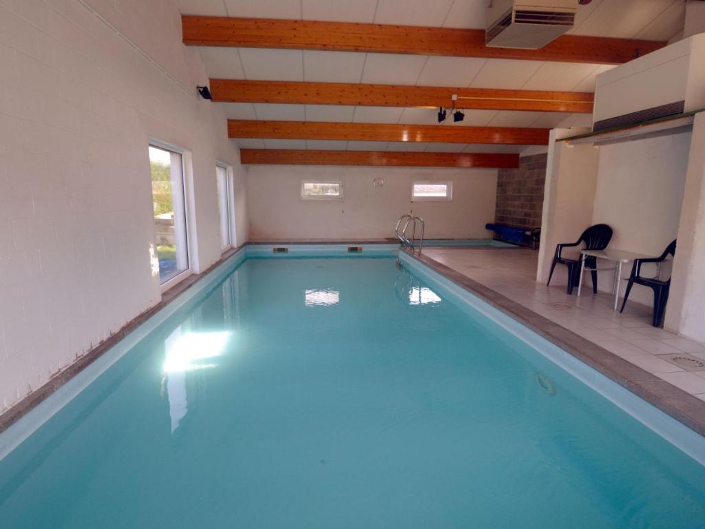 PurnodeQuaint holiday home with heated indoor pool的游泳池位于带桌椅的房间