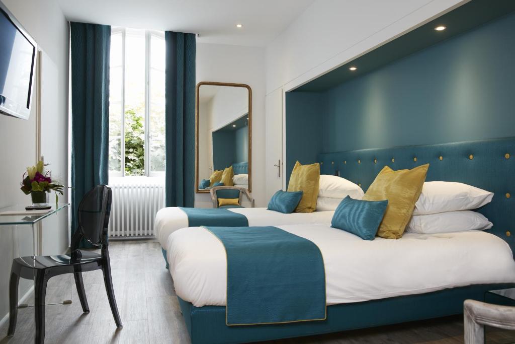 朗贡Logis Hôtel - Restaurant Maison Claude Darroze的两张位于酒店客房的床,拥有蓝色的墙壁