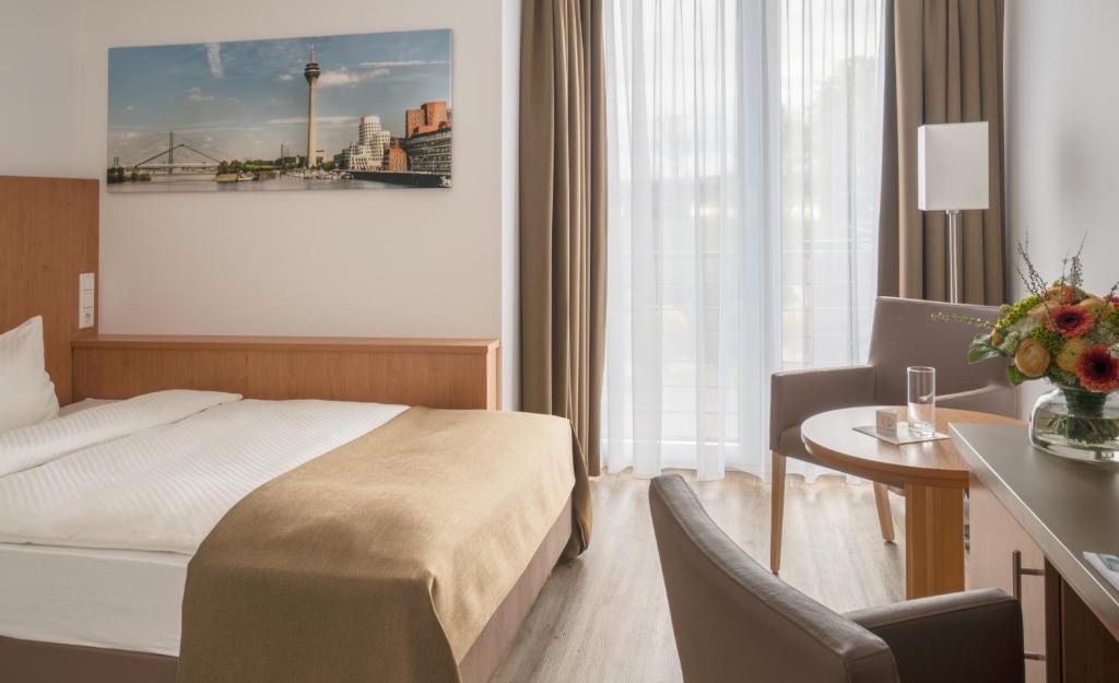 杜塞尔多夫克里斯马酒店的酒店客房配有一张床、一张桌子和一把椅子。