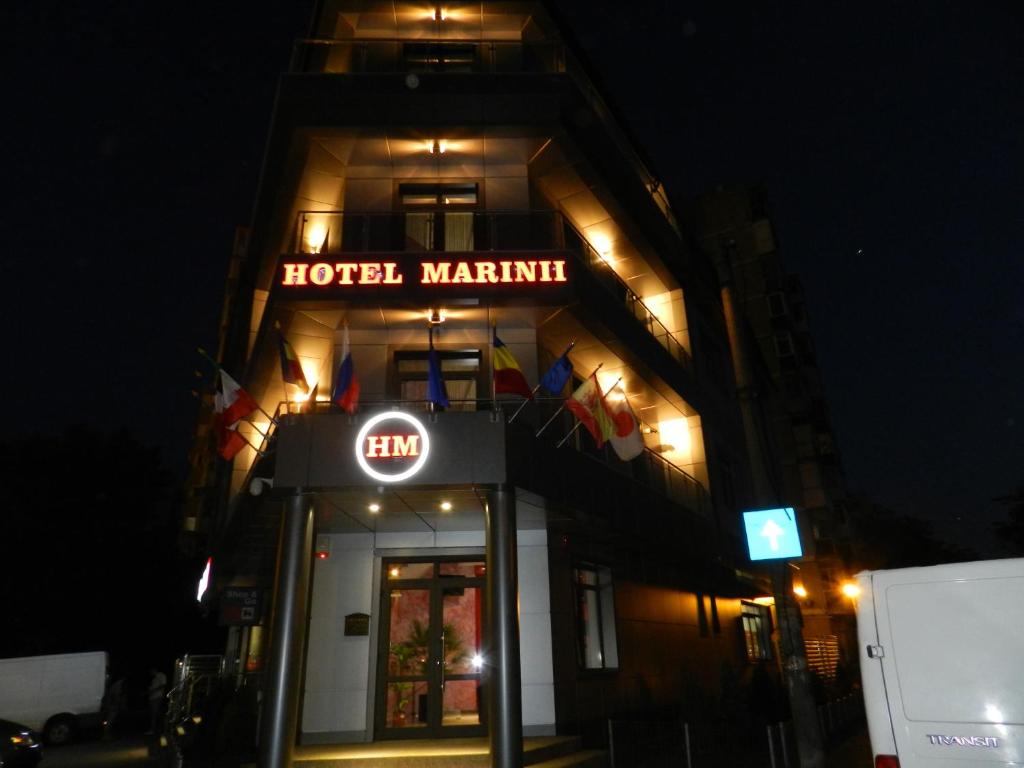 布加勒斯特Hotel Marinii的夜间在大楼前的酒店马提尼标志