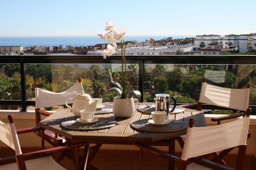 阿利坎特Canaima Alicante的一张带椅子的木桌和一张桌子,享有美景