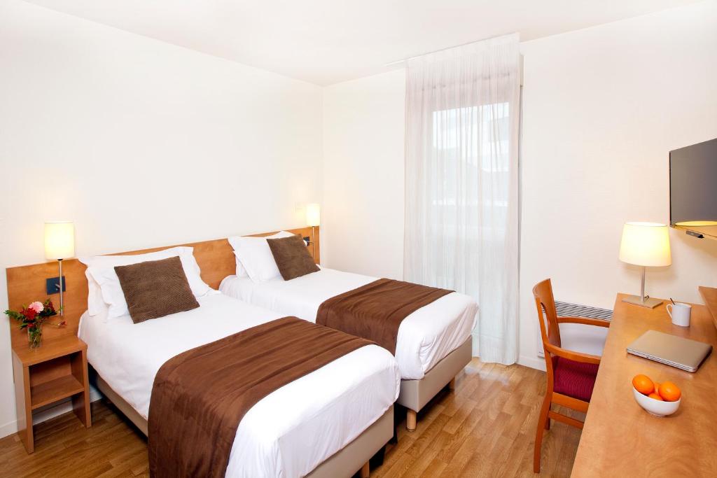 雷恩雷恩龙领域公园和商务酒店的酒店客房配有两张床和一张书桌