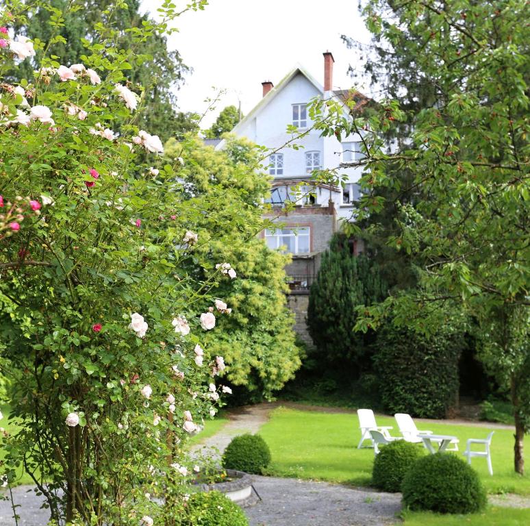 杜柏美好年代别墅住宿加早餐酒店的一座花园,花园前有两把白色椅子和玫瑰
