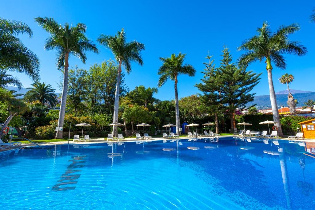 拉克鲁斯玛萨罗公寓酒店的一个带椅子和棕榈树的大型游泳池