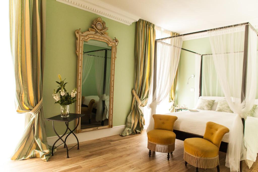 AtinaPalazzo del Senatore的一间卧室配有一张床、镜子和两把椅子