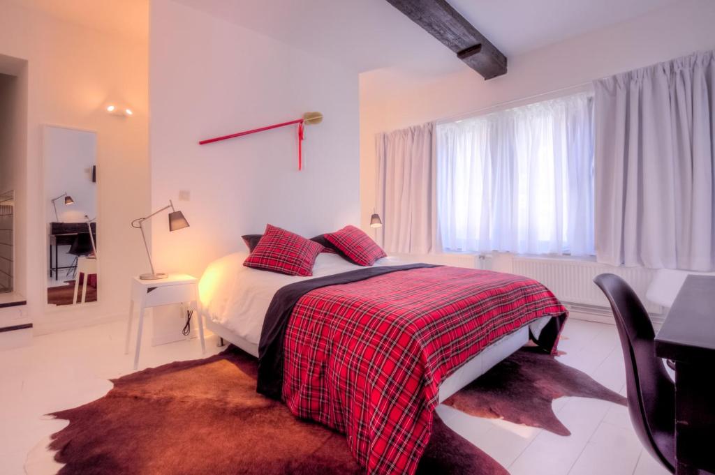蒙斯Mons Dragon House的一间卧室配有一张带红色和黑色毯子的床