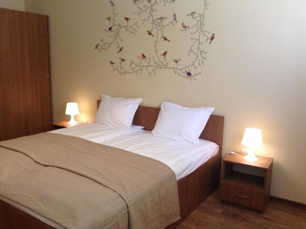 索非亚Apartment Sredetz的一间卧室配有一张带两盏灯的床,墙上挂有一幅画