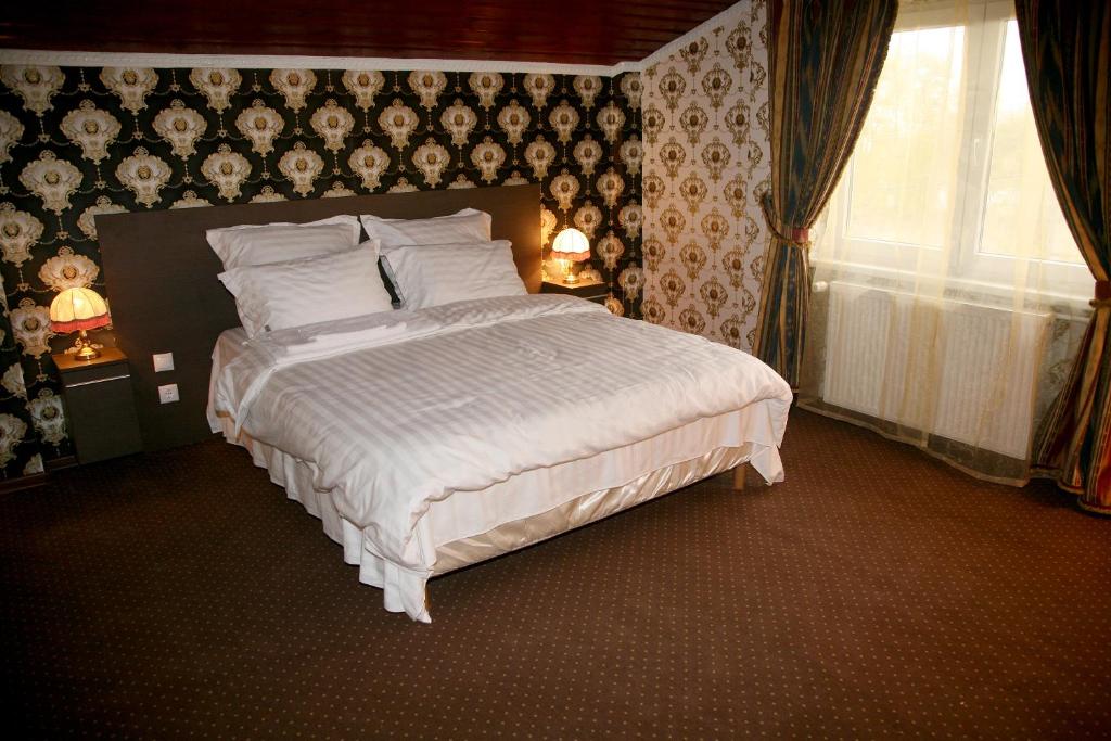 DaiaPensiunea Lokanta的一间卧室设有一张大床和一个窗户。