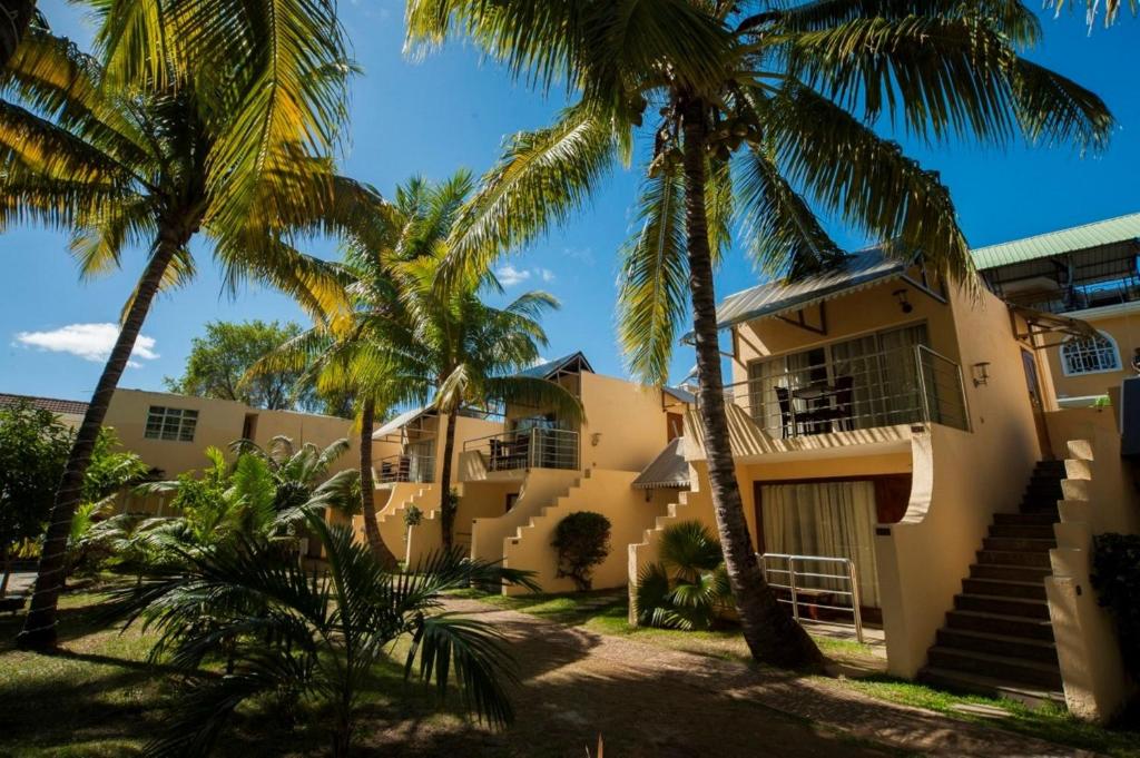弗利康弗拉克马尼萨酒店的前面有棕榈树的房子