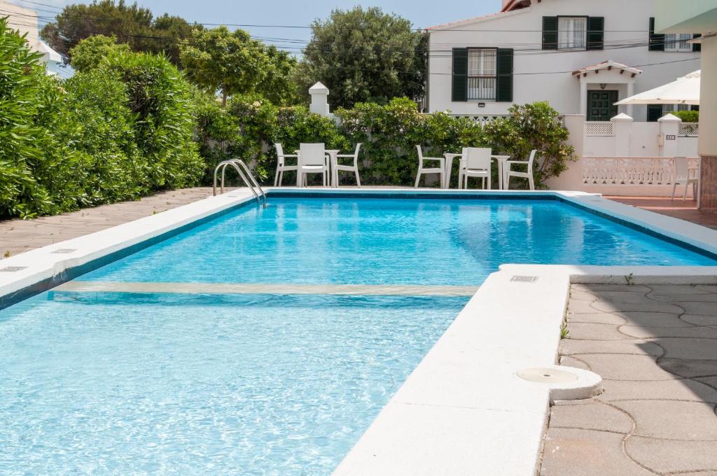 休达德亚马德里酒店的一个带椅子的庭院和房子的游泳池