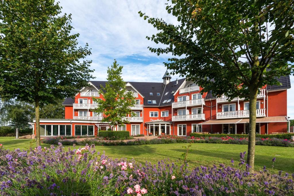 瓦尔内明德施特兰德哈弗公寓酒店的一座大建筑前面有鲜花