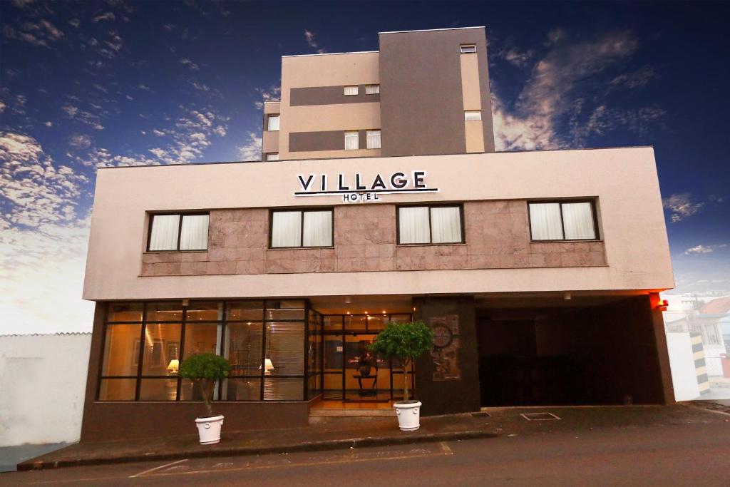 蓬塔格罗萨Village Hotel的一座带有读取乡村酒店标志的建筑
