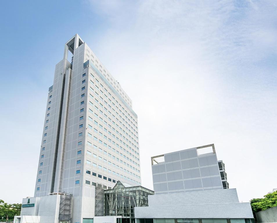 横滨横滨化工技术大厦酒店的一座高大的白色建筑,天空