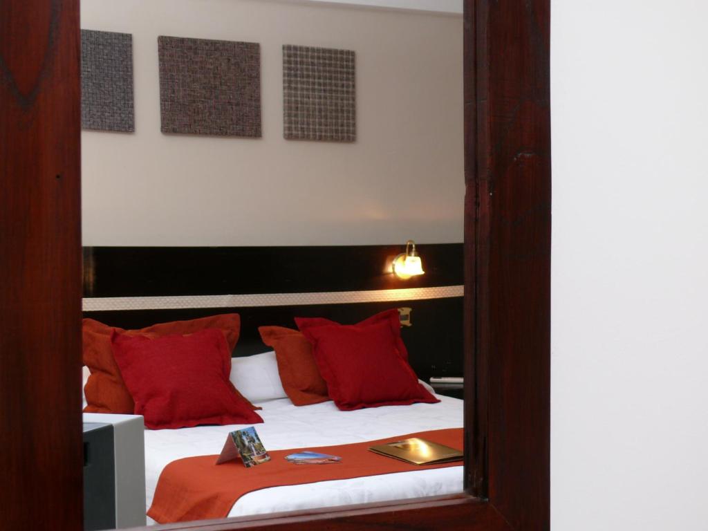 圣萨尔瓦多德朱格雷戈里奥一世精品酒店的一间卧室配有一张带红色枕头和镜子的床