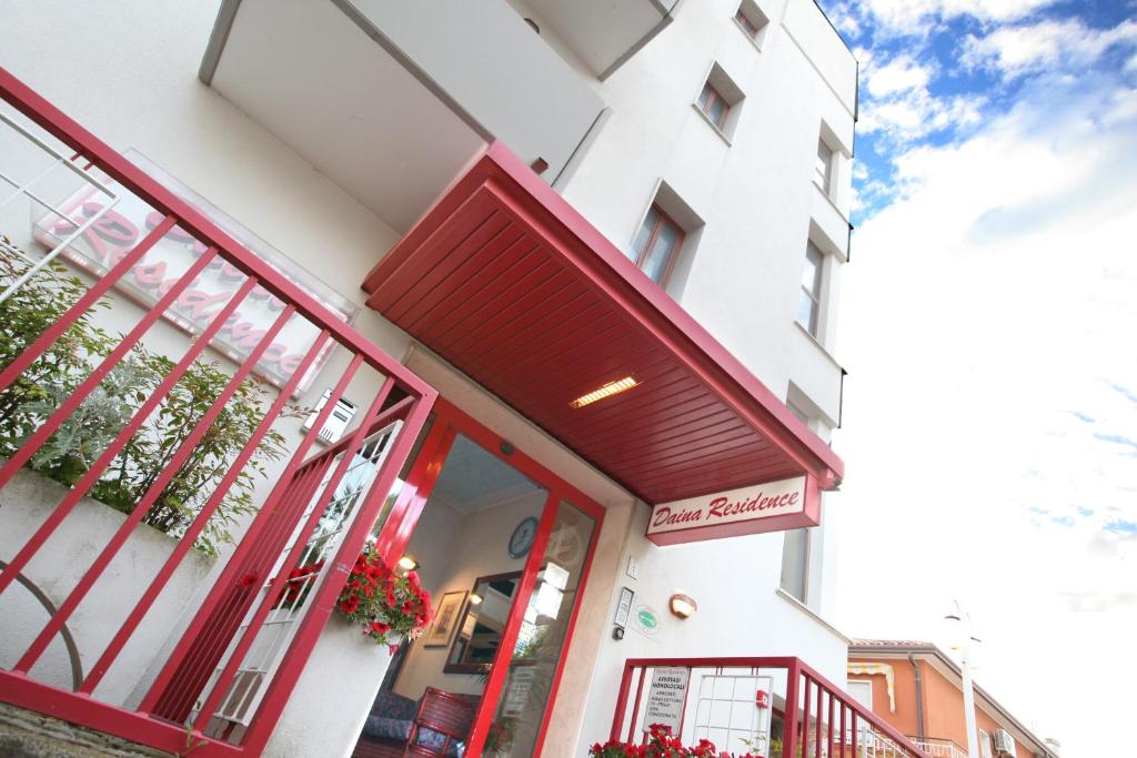 利多迪耶索罗Daina Residence的一座建筑前面的商店,有一道红色的门