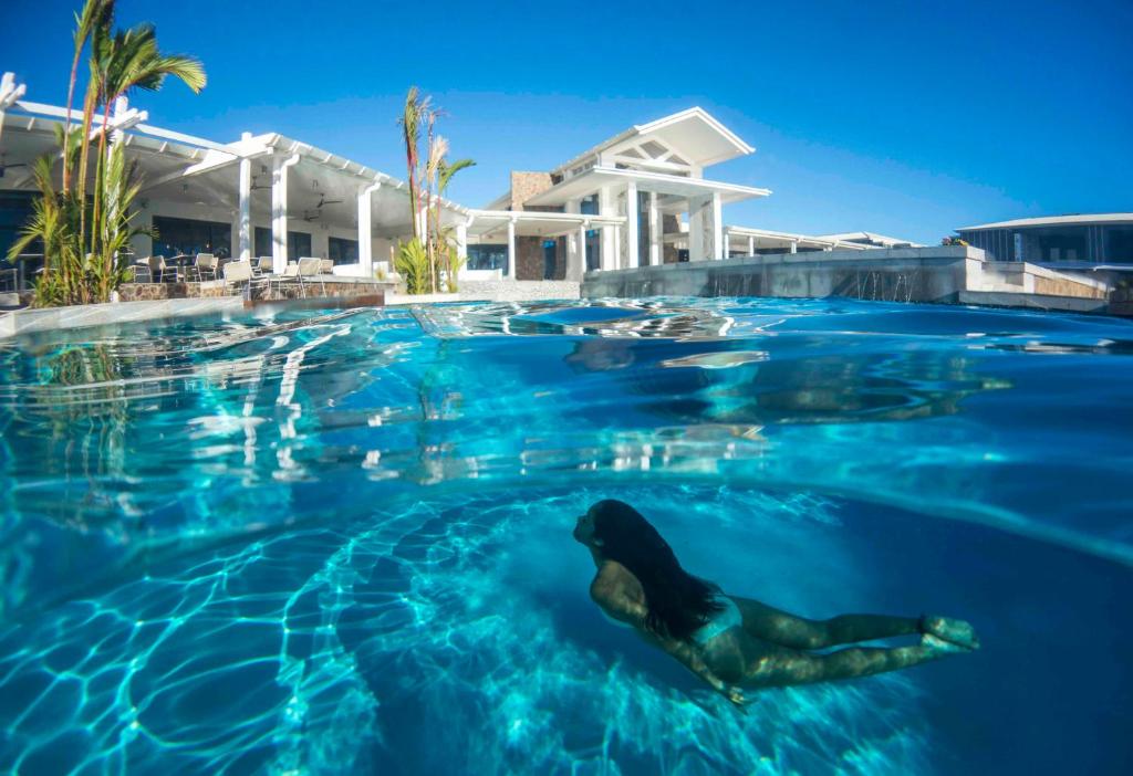 阿皮亚托米西纳岛度假酒店的美人鱼在房子前的游泳池游泳