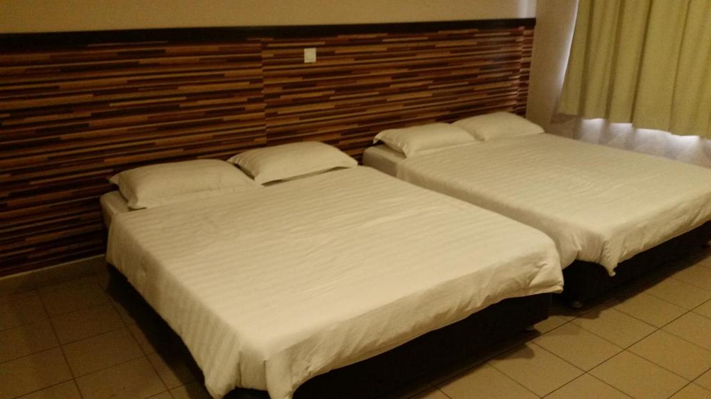 哥打京那巴鲁Hotel Iskandar的卧室内两张并排的床