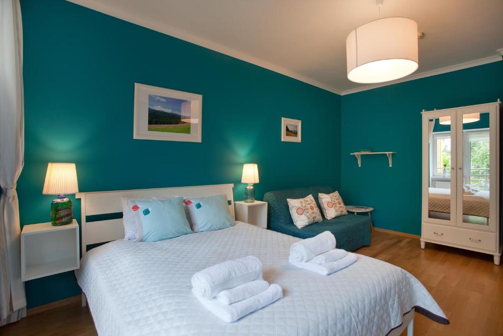 克雷尼察Trzy Siostry的卧室配有白色大床和蓝色的墙壁