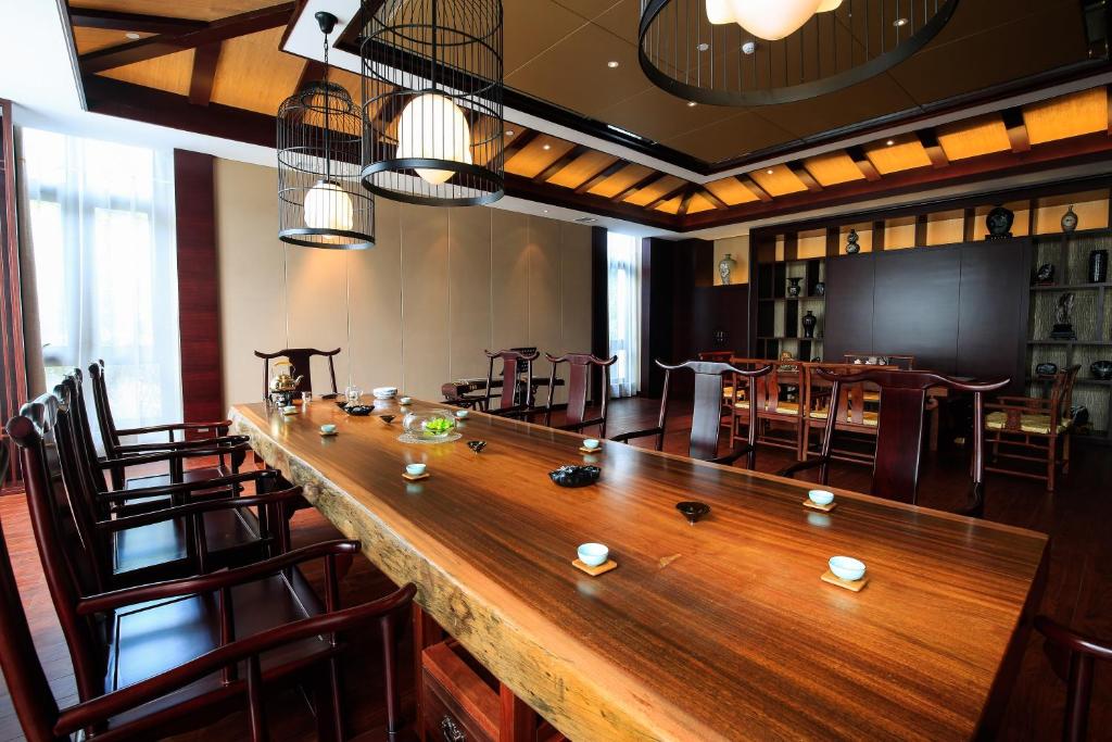 吉安庐陵东方宾馆的一张大长木桌子,位于带椅子的房间
