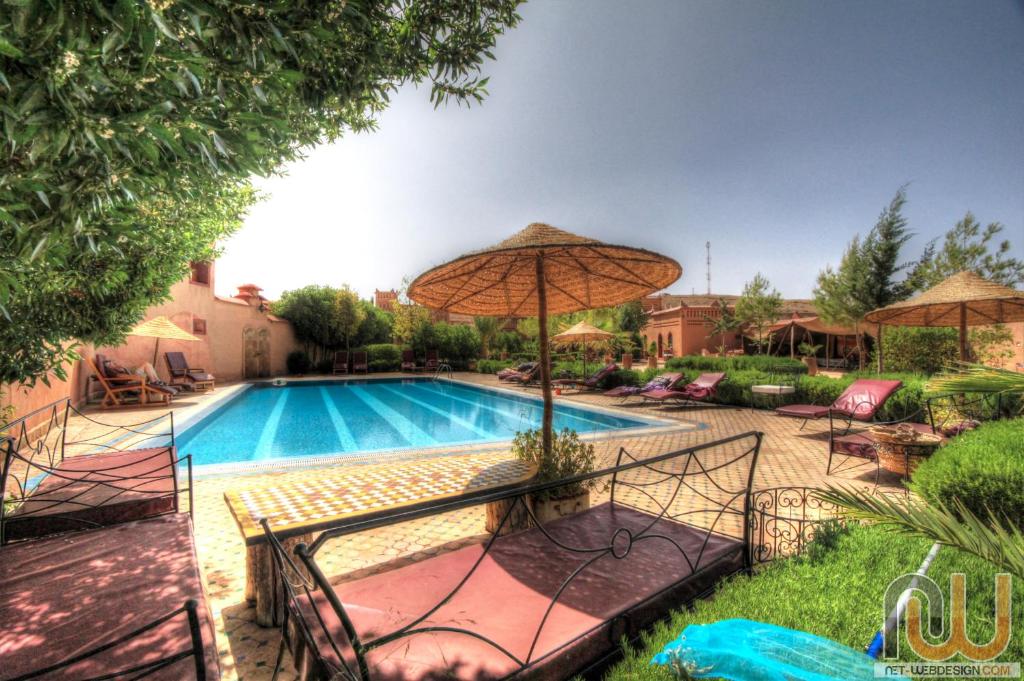 布马伦拉佩尔勒杜大德斯酒店的一个带遮阳伞和椅子的游泳池以及一个游泳池