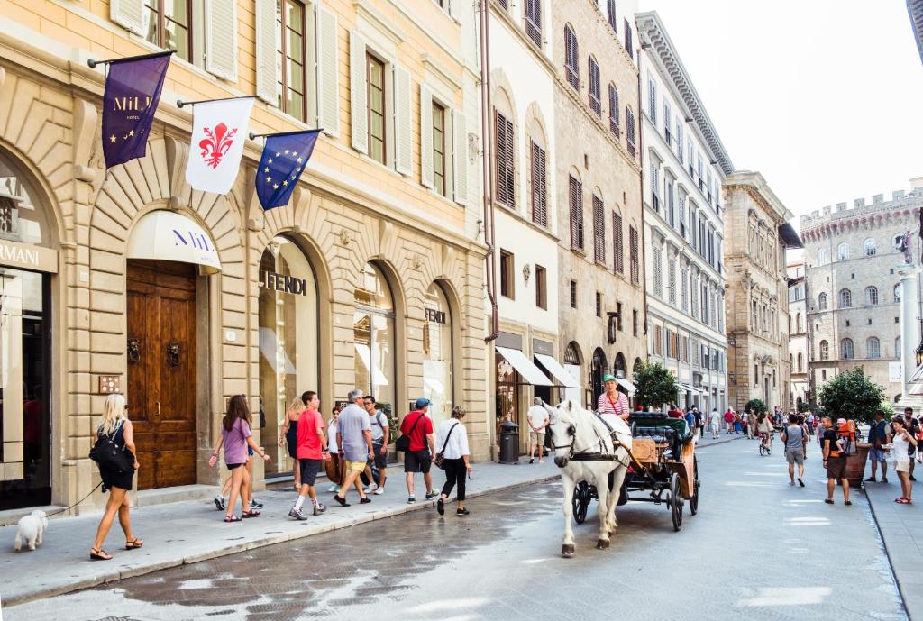 佛罗伦萨米卢酒店的一条马车在城市街道上与人们一起