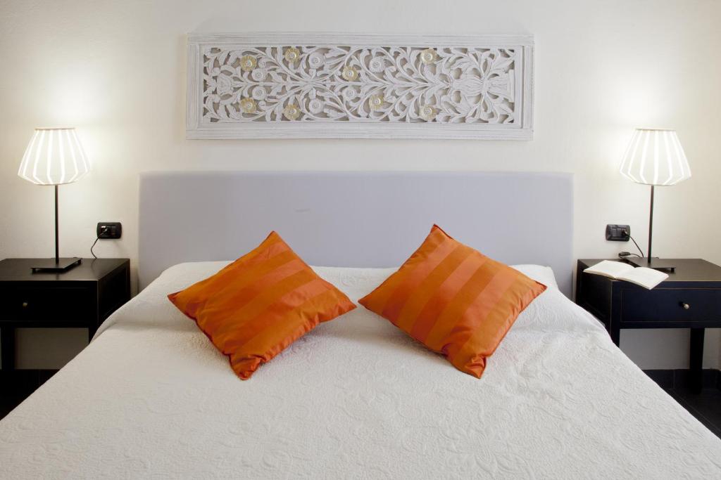 佛罗伦萨坎托戴米勒旅馆的卧室配有白色床和2个橙色枕头