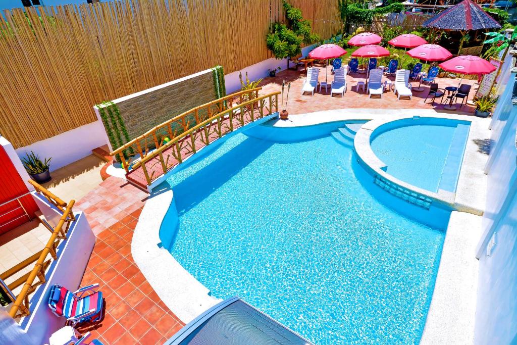 长滩岛长滩岛红可可旅馆的庭院内一个带椅子和遮阳伞的游泳池