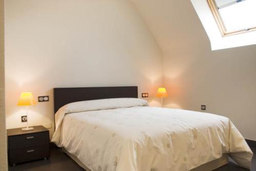 阿尔切纳阿奇巴尔套房公寓的卧室配有白色的床和两盏灯。