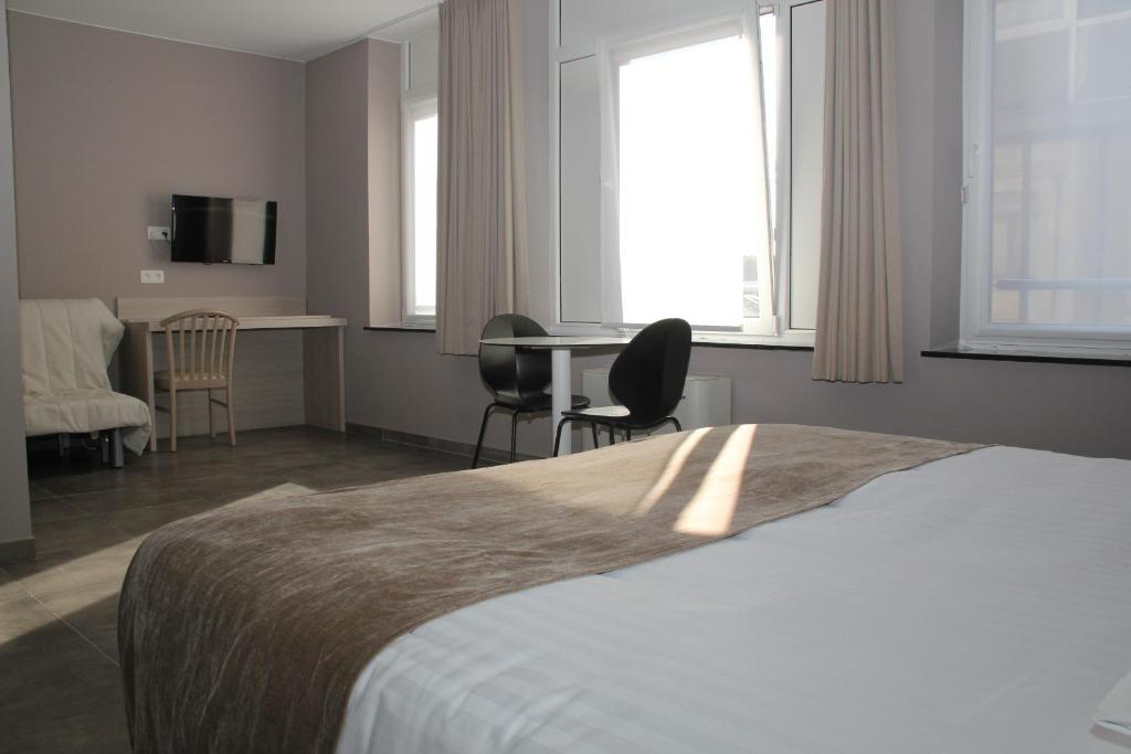 拉卢维耶尔卢维酒店的卧室配有一张床和一张桌子及椅子