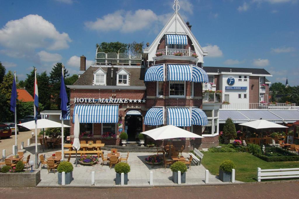 卑尔根弗莱彻莫杰克餐厅酒店的大楼前有桌子和遮阳伞的酒店