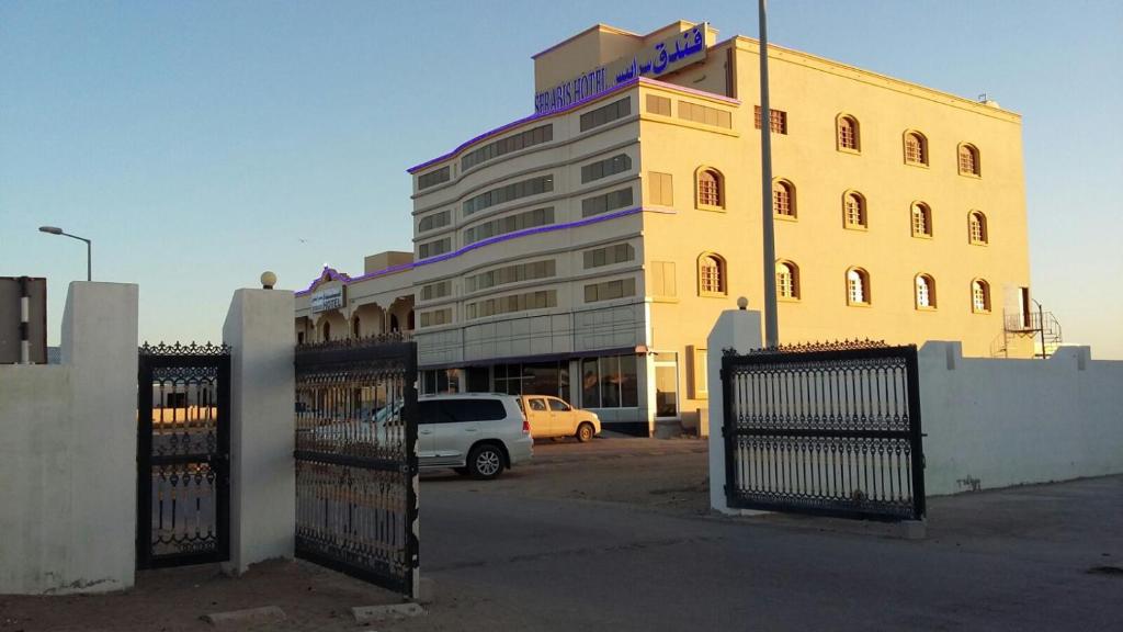 Ḩilf萨拉匹斯酒店的前面有一辆白色面包车的黄色建筑