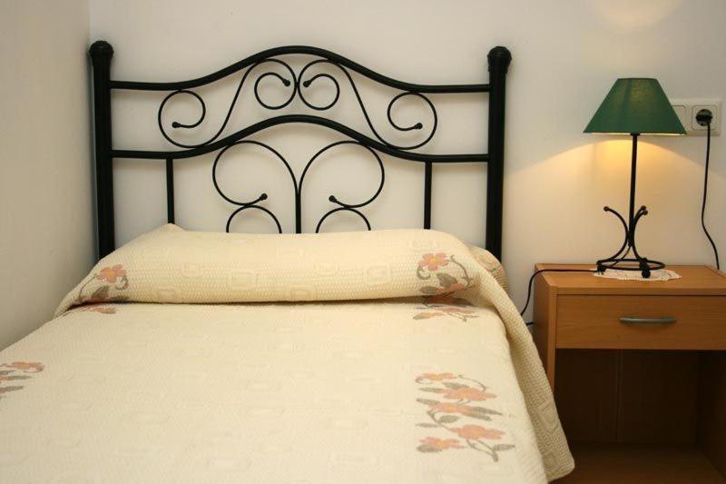 瓜达莱斯特Alojamientos Rurales Aitana的一间卧室配有一张带黑色床头板和灯的床。