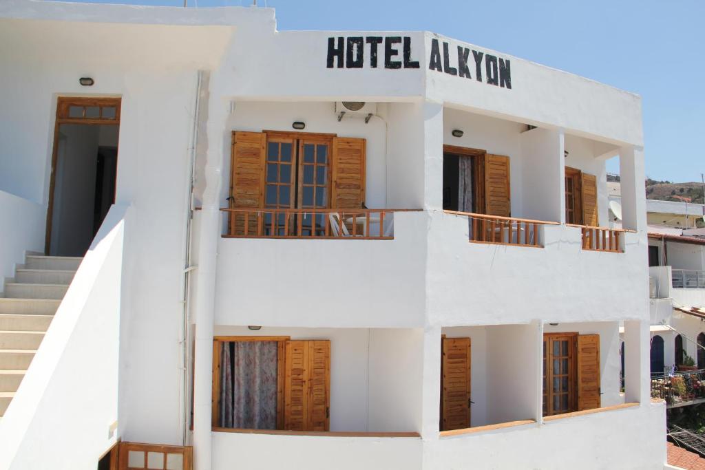 霍拉斯法基翁Hotel Alkyon的上面有酒店顾问标志的白色建筑
