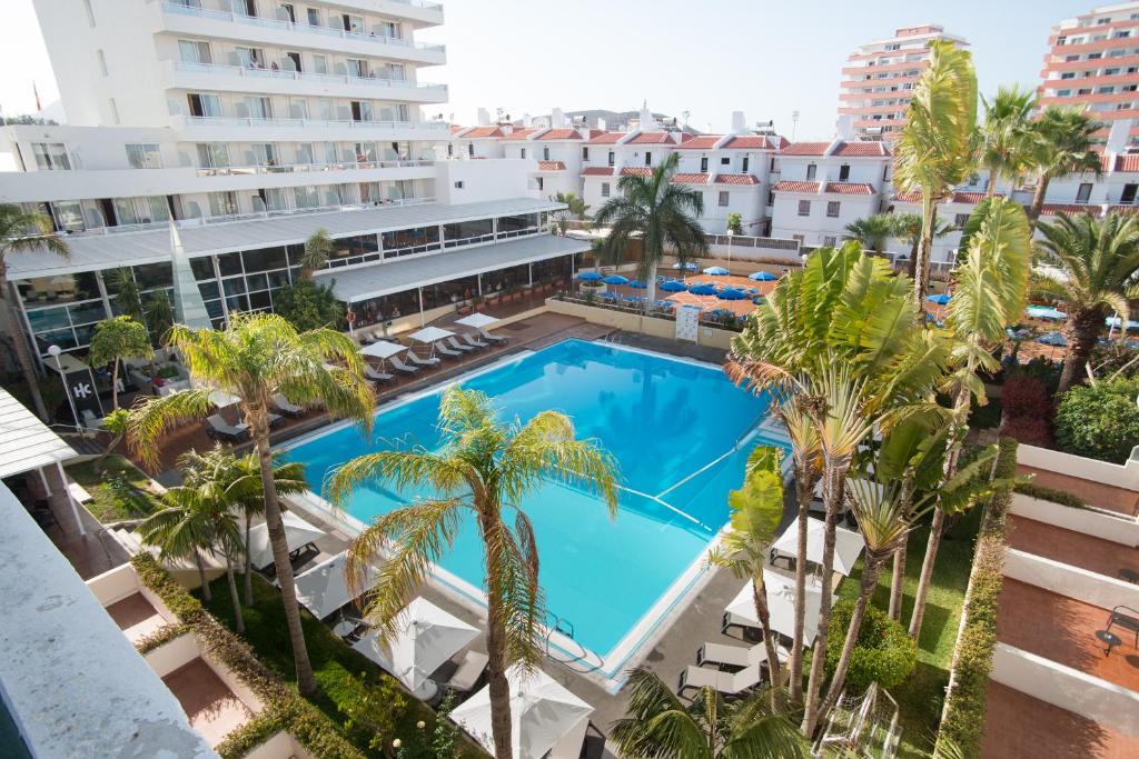 美洲海滩加泰罗尼亚黑金酒店的享有棕榈树和建筑的游泳池的顶部景致