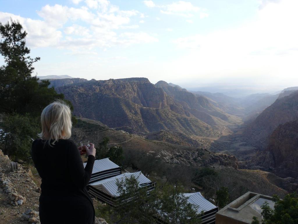 达纳Dana Village Camp-Wadi Dana Eco camp的站在山顶望峡谷的女人