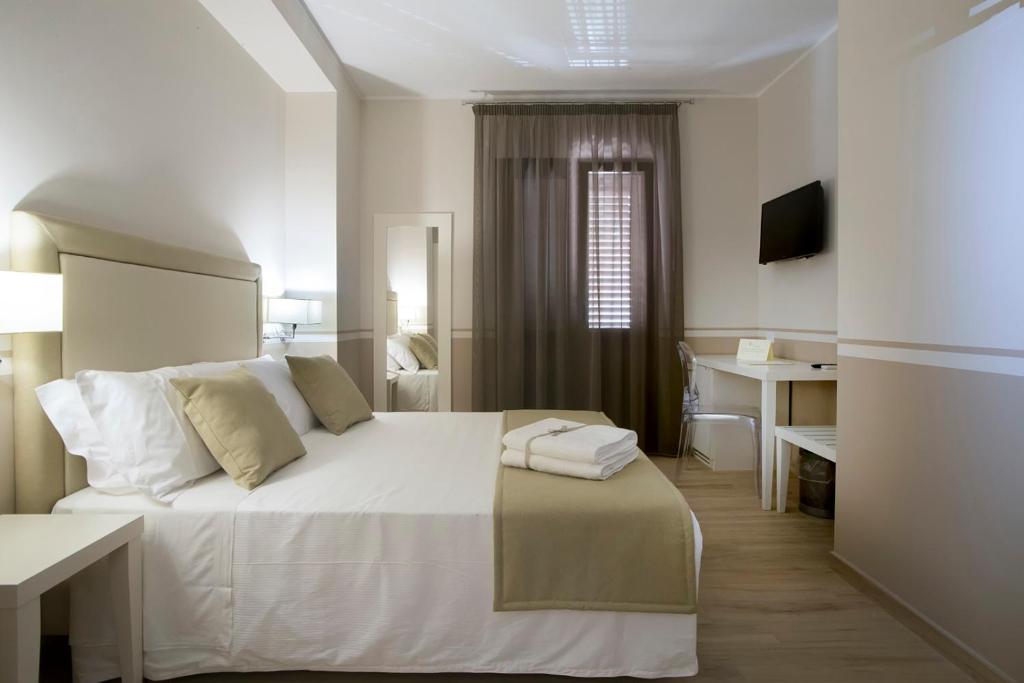 圣维托罗卡波Eunice Bed and Breakfast的一间酒店客房,配有一张白色的床和一张书桌