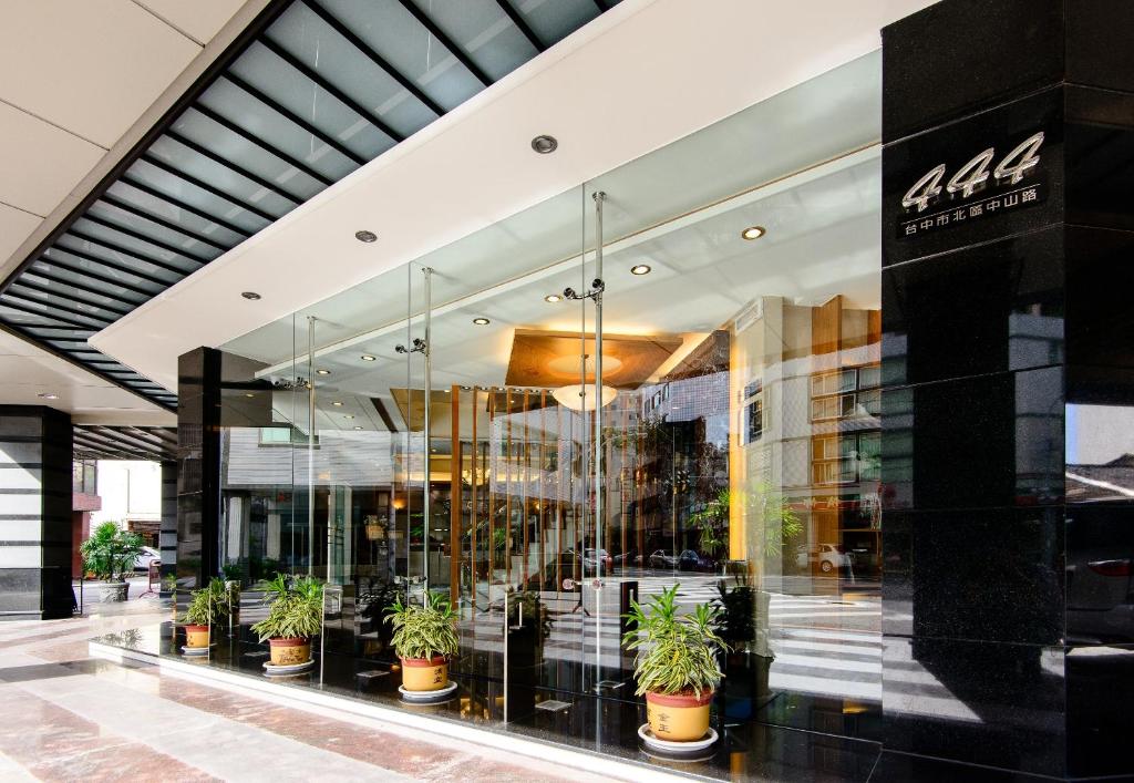台中市高苑商務旅館中山店的一座种植盆栽植物的建筑的前方