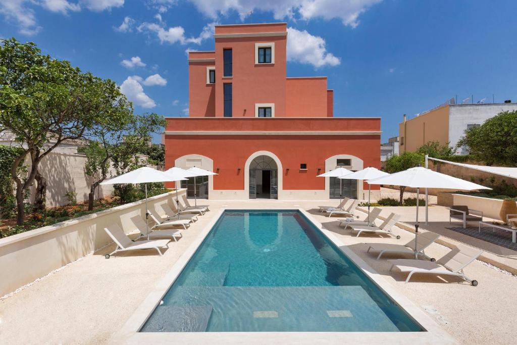 卡萨拉诺Palazzo Fasti的一座带躺椅的游泳池和一座建筑