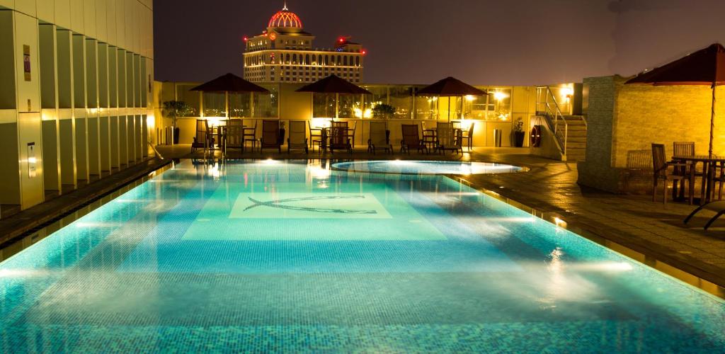 迪拜象牙豪华公寓酒店的夜间在建筑物屋顶上的游泳池