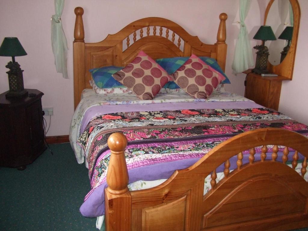 基拉尼修道院美景住宿加早餐旅馆的一间卧室配有一张带色彩缤纷枕头的木床。