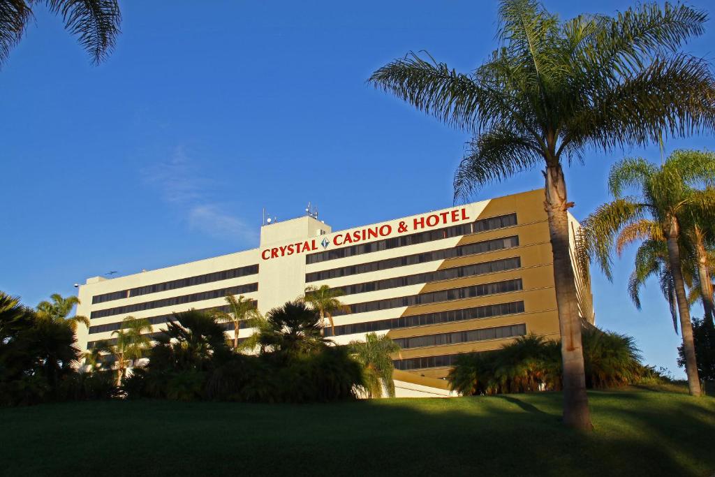 卡森LA Crystal Hotel -Los Angeles-Long Beach Area的前面有棕榈树的建筑