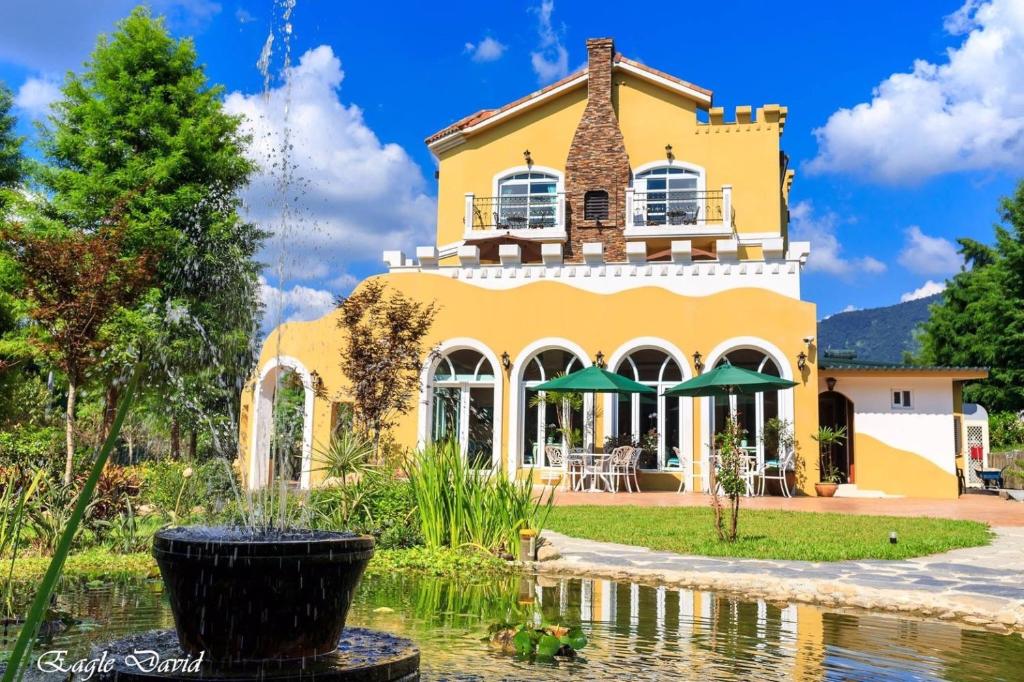 鱼池乡山閱聖堡羅莊園的前面有池塘的黄色房子