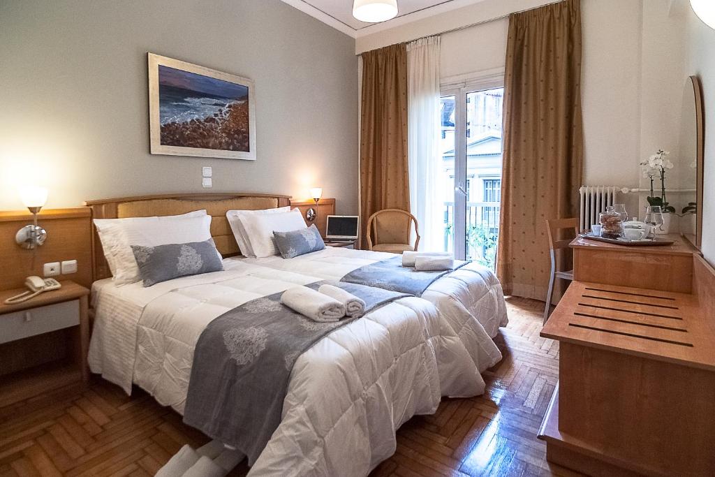 雅典雅典阿瑞斯酒店的一间卧室配有一张大床和两条毛巾