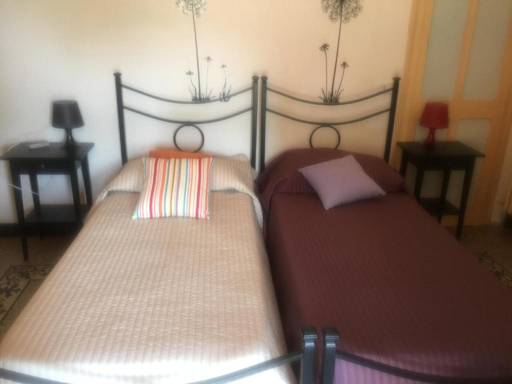 多尔切多Affitta camere Da Lalla的两张睡床彼此相邻,位于一个房间里
