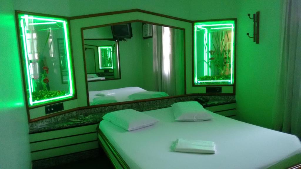 里约热内卢Magnus Norte Hotel (Adult Only)的绿色卧室配有床和镜子