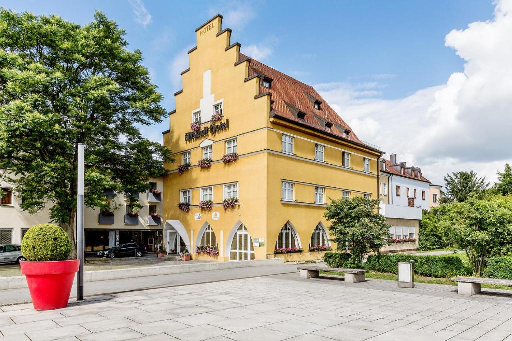 安贝格老城酒店的前面有红色桶的黄色建筑